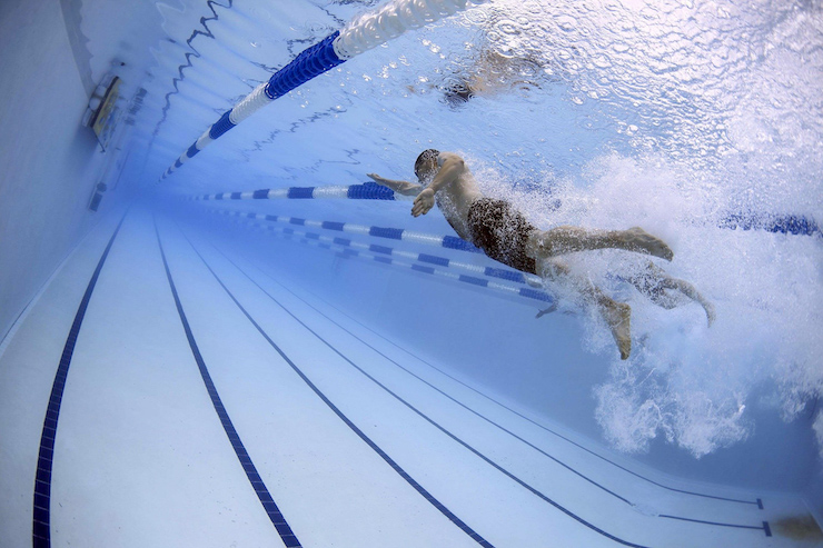 Mann schwimmt im Wasser Bahnen